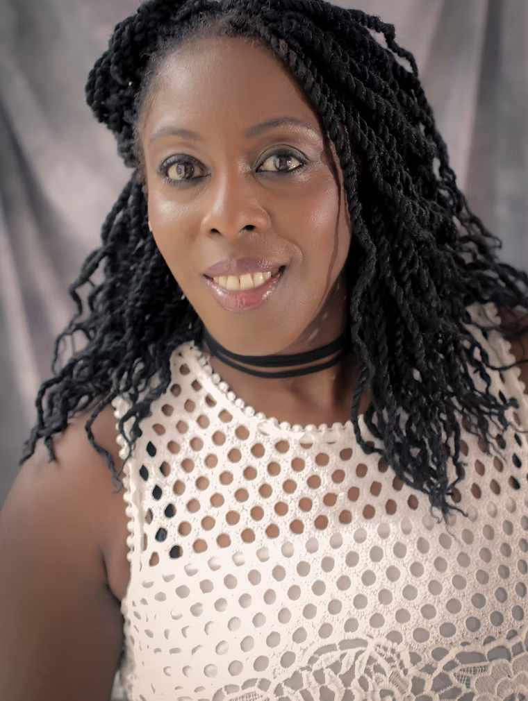 Professional head-and-shoulders photograph of Yvonne Henry, a Black woman with shoulder-length hair and a warm, calm expression, wearing professional attire against a neutral background.
