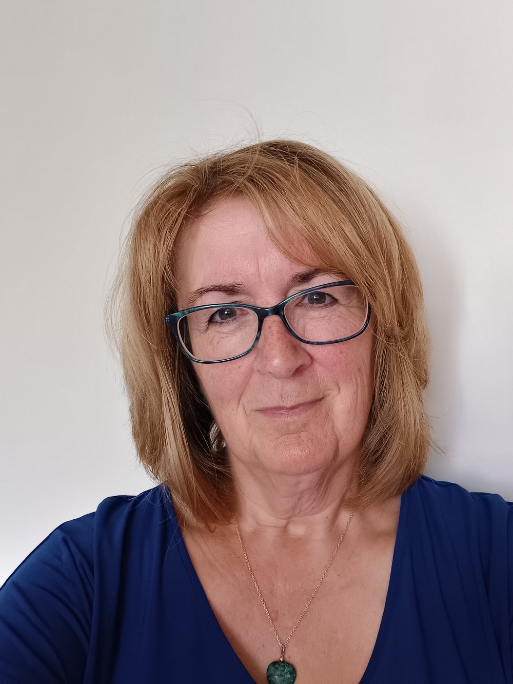 Headshot of counsellor Alison Burgess smiling, wearing a blue top