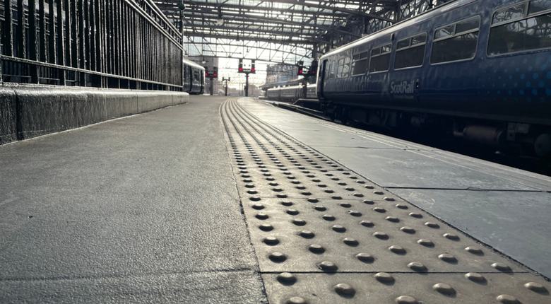 A tactile paving strip along the platform edge at a station, providing a safe warning of the platform edge.