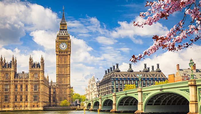 A scenic view of Westminster bridge and the Houses of Parliament on a sunny day.