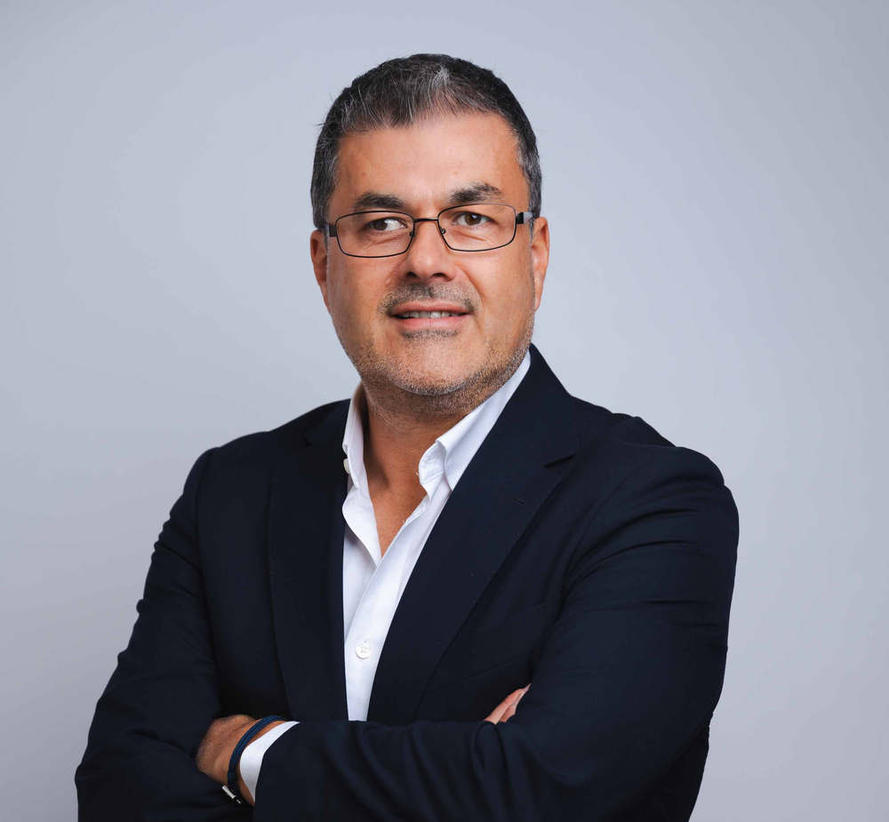 A picture of Barry Hoffman, a man with short black and grey hair wearing glasses and a navy suit, smiling at the camera