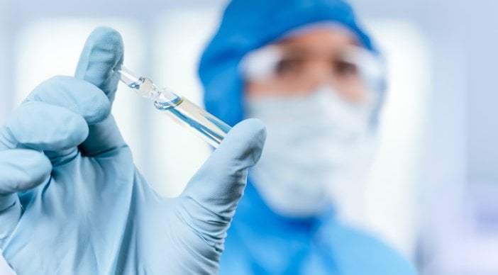 A person holds a vial of COVID-19 vaccine.