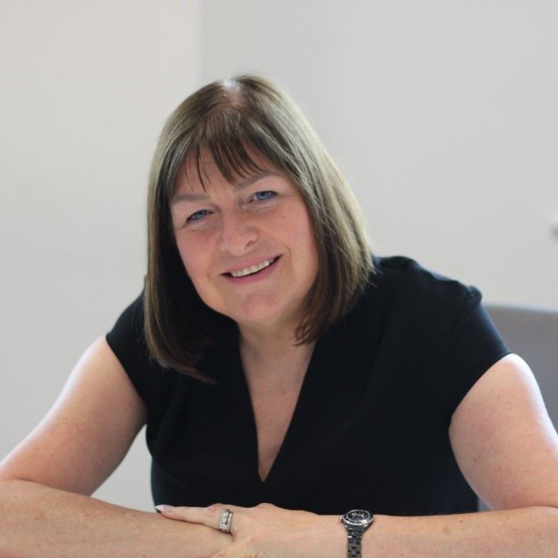 Debbie Bowring, a woman with short brown hair looking at the camera smiling