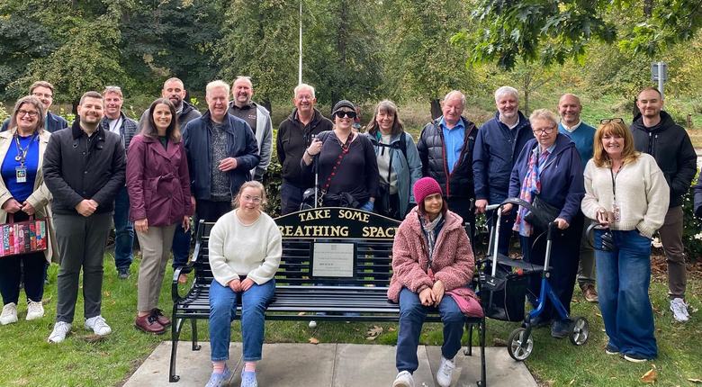 A group photo of community members around a Breathing Space bench near the RNIB Scotland office in Edinburgh.