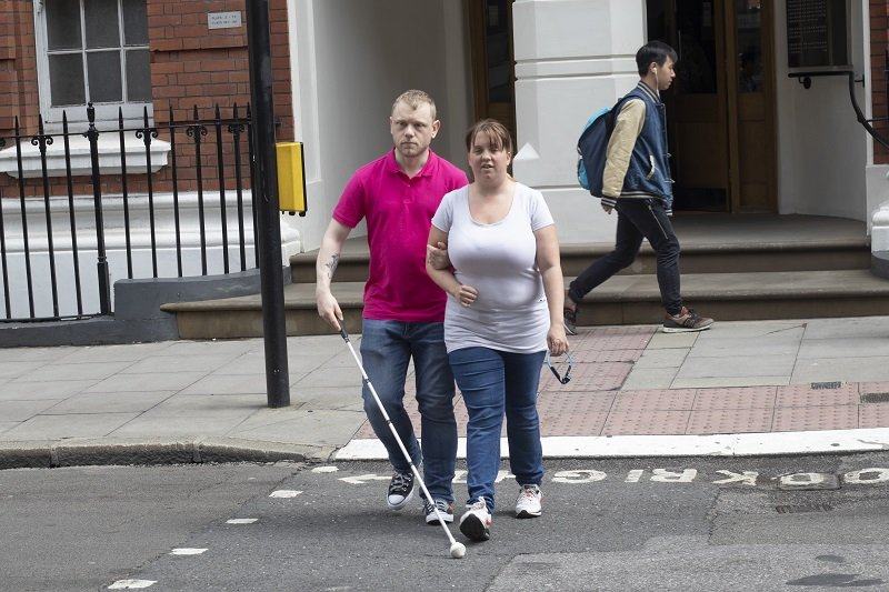 Hannah guiding Ray across the road