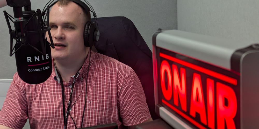 Hubert sat next to a red 'on air' sign, talking into a large radio microphone.