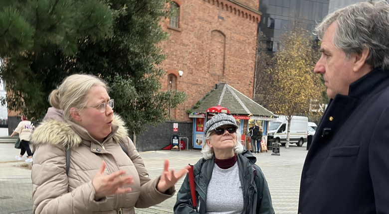 Liverpool City Region Mayor Steve Rotheram in conversation with RNIB staff, outdoors in Liverpool city centre.