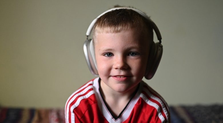 Image shows a child listening to an audiobook using headphones