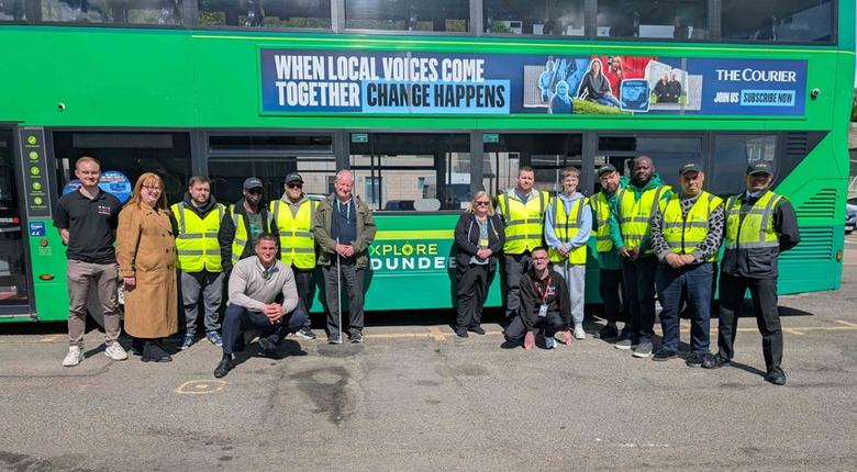 Group photo of bus drivers and RNIB Scotland volunteers in front of a bus.