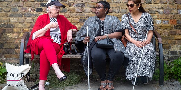 Three women talking to each other sat outside the RNIB office