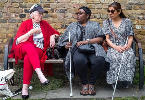 Three women talking to each other sat outside the RNIB office