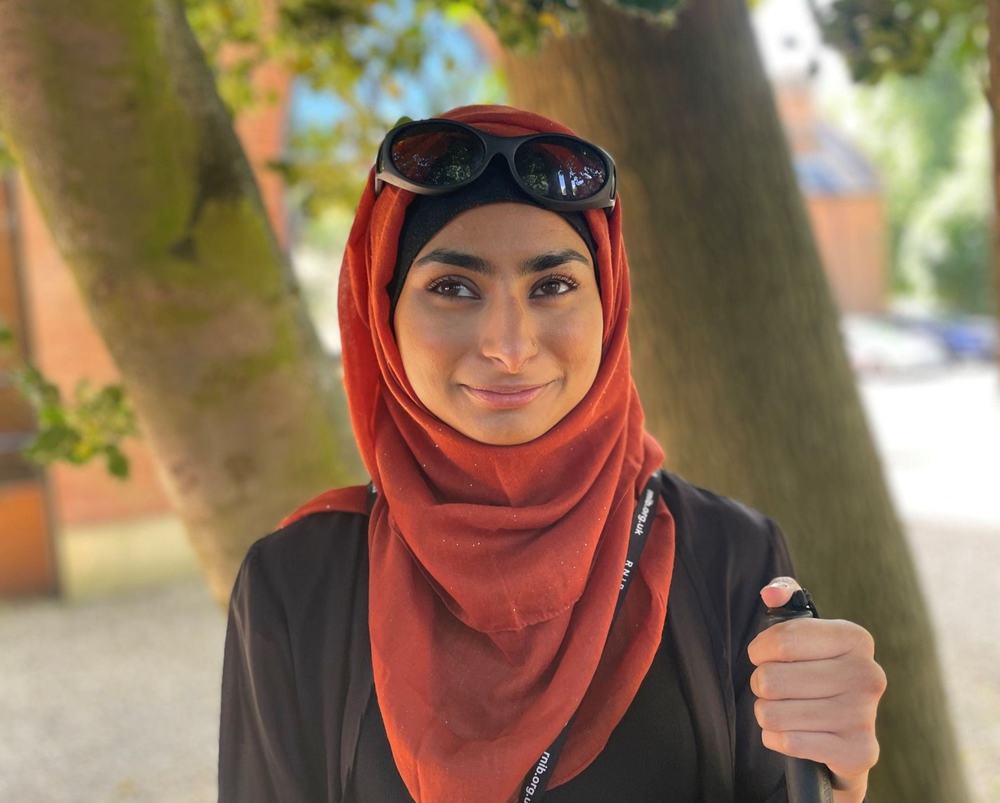Khadija stood under a tree on a sunny day.